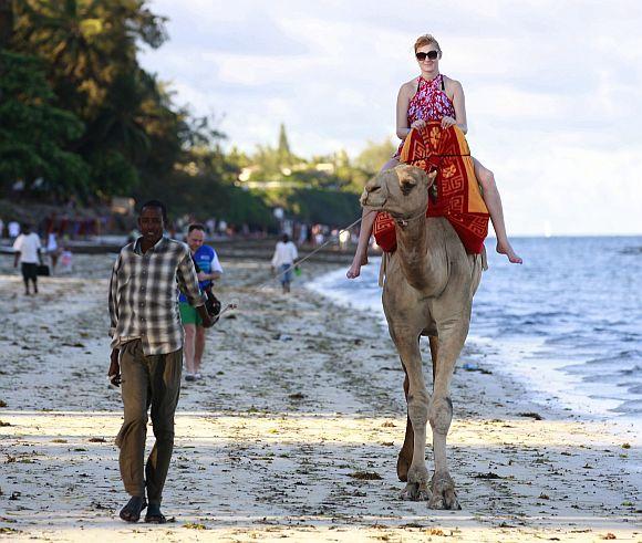 A tourist rides on a camel's back at the Jomo Kenyatta public beach in Kenya's coastal city of Mombasa