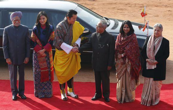 Bhutan's King Jigme Khesar Namgyel Wangchuck shakes hands with India's President Pranab Mukherjee as India's Prime Minister Manmohan Singh, Bhutan's Queen Jetsun Pema, Mukherjee's daughter Sharmistha Mukherjee and Singh's wife Gursharan Kaur look on during the king's ceremonial reception at the Rashtrapati Bhavan in New Delhi