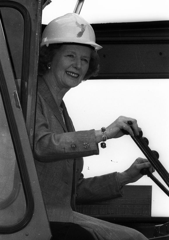 Helping to build an empire, Britain's Prime Minister Margaret Thatcher takes the controls of a crane to place an inaugural block of marble in London on July 11, 1986