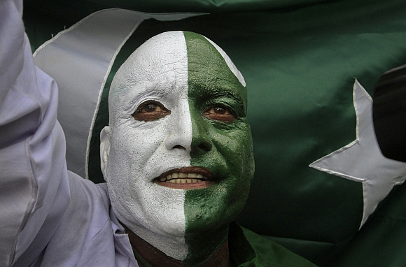 A man, with his face painted depicting the colours of the Pakistan national flag, attends a ceremony to mark the country's Independence Day at the Wagah border crossing with India on the outskirts of Lahore
