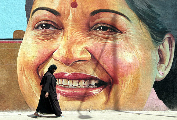 A woman walks past a portrait of Tamil Nadu CM J Jayalalithaa