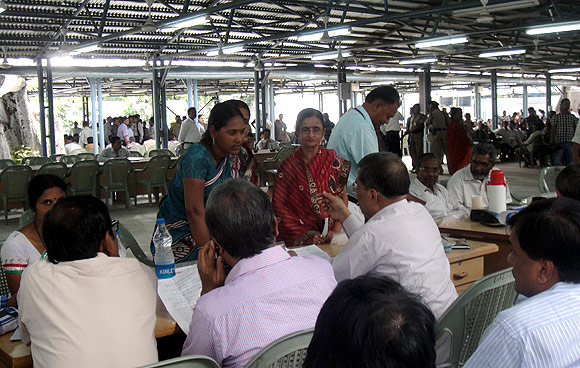 People are directed to different desks manned by government officials