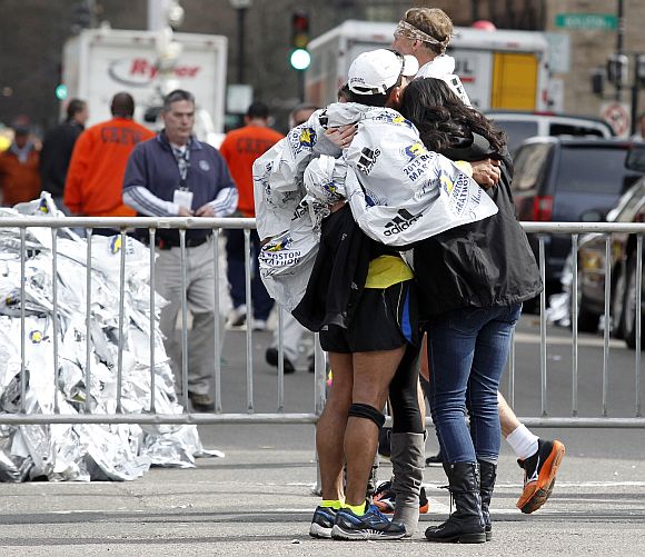 People comfort each other after explosions went off at the 117th Boston Marathon in Boston, Massachusetts