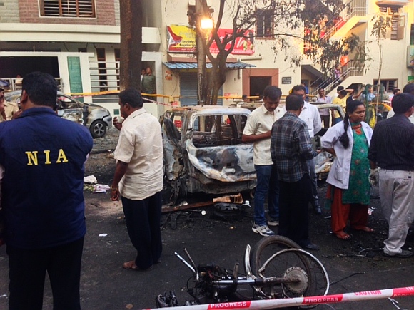 Officials from the NIA and forensic officials inspect the scene of a blast near the office of the Bharatiya Janata Party in Bangalore
