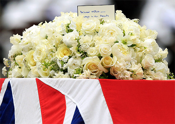 A close up shows flowers and a note on the Union Flag-draped coffin of former British prime minister Margaret Thatcher
