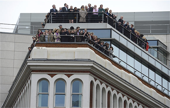 Office workers on balconies watch the funeral procession