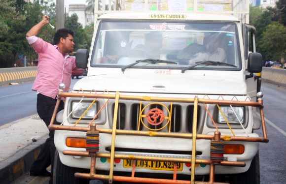 A protestor attacks a vehicle as bandh crippled normalcy in Thane city on Thursday