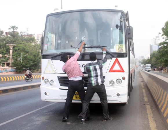 Protestors damage a bus during Thane bandh on Thursday