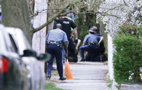 Police officers move towards a police assault on a house with their guns drawn as gunfire erupts on Franklin Street during the search for Dzhokhar Tsarnaev