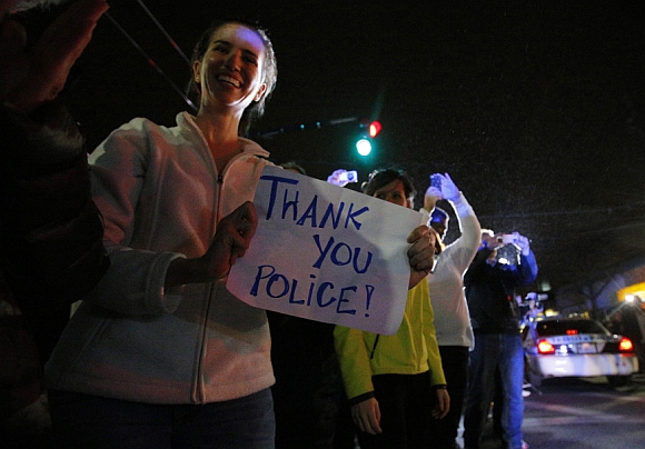 Members of the public cheer as police officers leave the scene where Dzhokhar was taken into custody in Watertown, Massachusetts