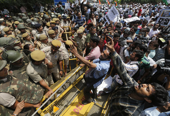 Demonstrators shout slogans as they try to cross a police barricade during a protest