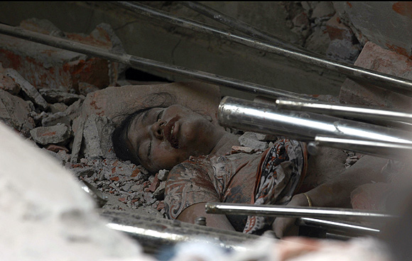 The body of a garment worker is seen amongst the rubble