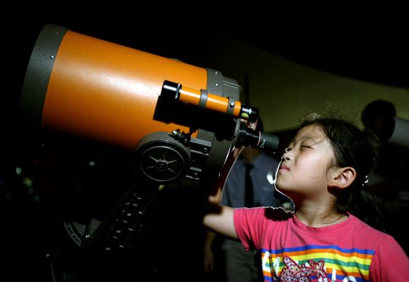 A Chinese girl takes a closer view of Mars through a telescope in Shanghai
