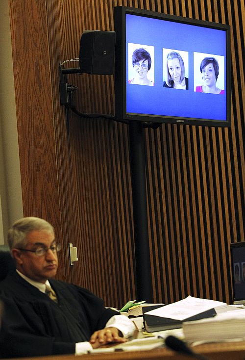 Judge Michael J Russo looks on as the images of the three Cleveland kidnapped women (L-R) Michelle Knight, Amanda Berry and Gina DeJesus are shown on a television screen during the sentencing