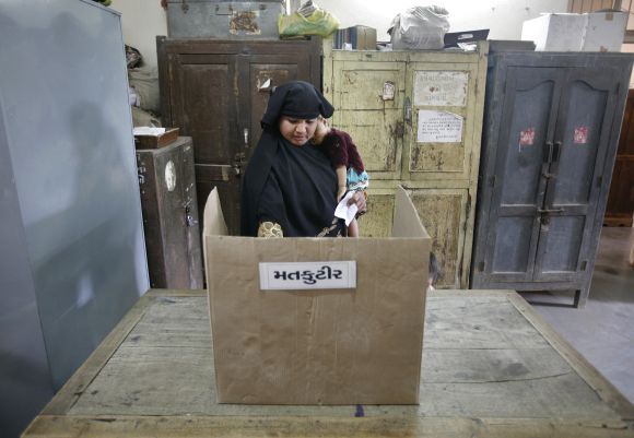 A woman casts her vote at a polling booth in Gujarat
