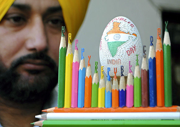 Harwinder Singh Gill, an artisan, displays his creation of an Indian map carved on an eggshell and Happy Republic Day carved on pencil leads on the eve of India's Republic Day celebrations in Amritsar 