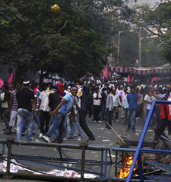 A pro-Telangana supporter throws a coconut towards police during a protest in Hyderabad.