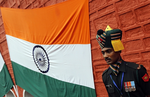 An Indian soldier stands next to an Indian national flag during the full-dress rehearsal for Independence Day celebrations at the historic Red Fort in Delhi. 