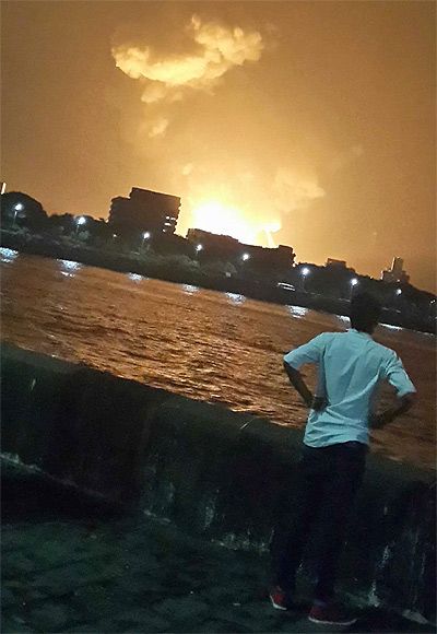A man watches Indian Navy submarine INS Sindhurakshak on fire in Mumbai on Wednesday