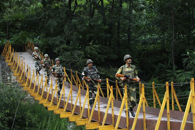 BSF soldiers patrol over a footbridge built over a stream near the Line of Control at Sabjiyan sector of Poonch district.