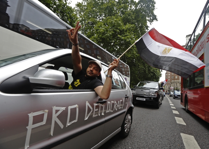 Supporters of Morsi demonstrate as they slow drive through central London