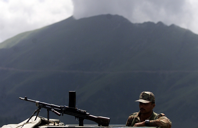 An army soldier keeps watch during a presentation of killed terrorists to media by the Indian army at an altitude of 11,000 feet at Keran sector, some 180 km from Srinagar
