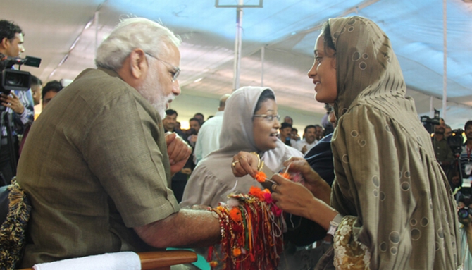 A Muslim woman ties a 'rakhi' to Narendra Modi on Tuesday