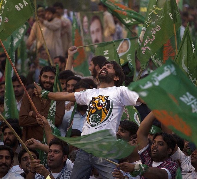 A supporter of the Pakistan Muslim League -- Nawaz (PML-N) party shouts slogans with others waving the party flags