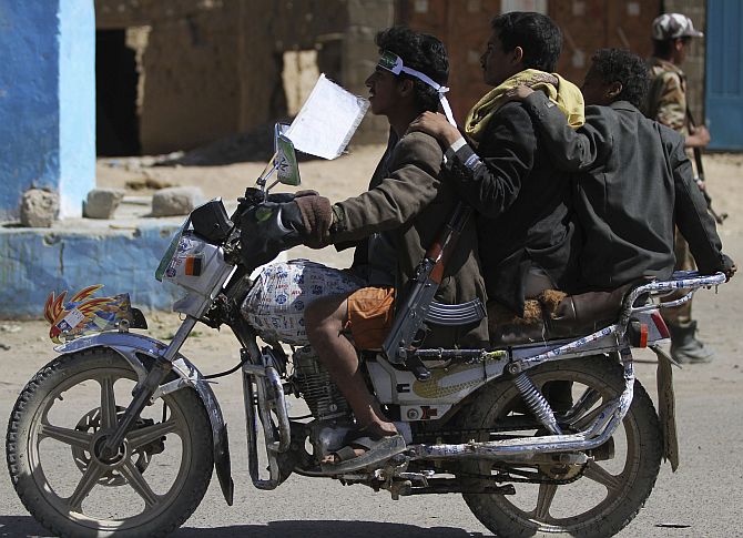 Followers of Yemen's al-Houthi Shi'ite group ride a motorcycle while carrying weapons, in the northwestern province of Saada