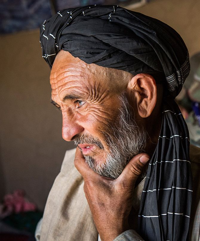 A local Afghan man waits while soldiers in the Afghan National Army's 6th Kandak (battalion), 3rd company search his home