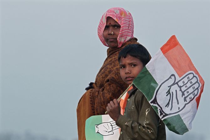 Supporters holding flags of India's ruling Congress party leave after attending an election campaign rally by Rahul Gandhi in Uttar Pradesh