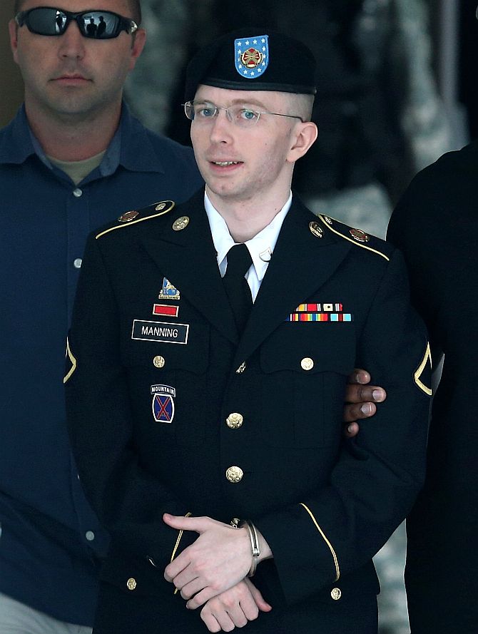 US Army Private First Class Bradley Manning is escorted by military police as he leaves his military trial