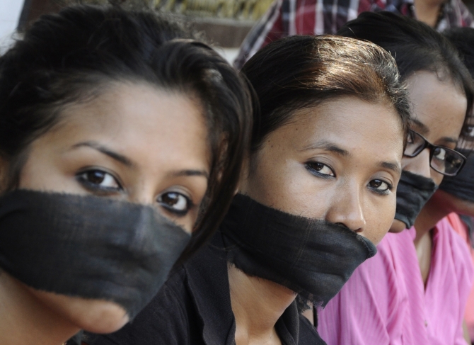 Members of the All Assam Photojournalist Association wear black sashes around their mouths during a protest against the rape of a photojournalist by five men in Mumbai