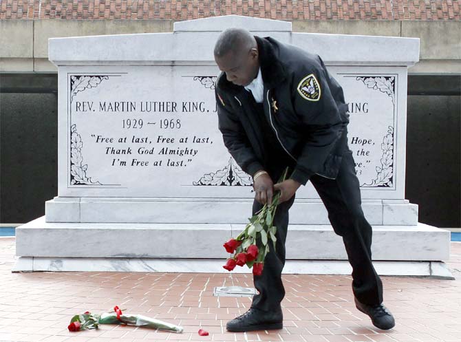 King Centre security officer Kevin Baxter collects roses left at the crypt of Dr Martin Luther King, Jr in Atlanta.