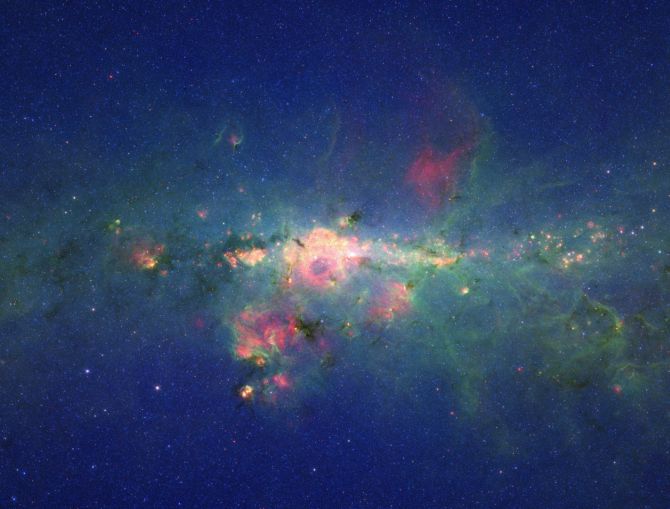 The region around the centre of our Milky Way galaxy glows colorfully in this image taken by Spitzer telescope.