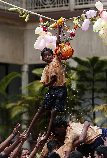 A visually impaired student breaks a clay pot containing curd during celebrations for the Janmashtami in Mumbai.