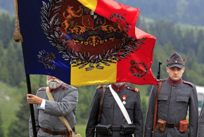 Participants dressed in 1916 Romanian troops uniforms stand behind their banner before the re-enactment of a battle in World War One at a Military History festival organised in Fundata village near Bucharest 