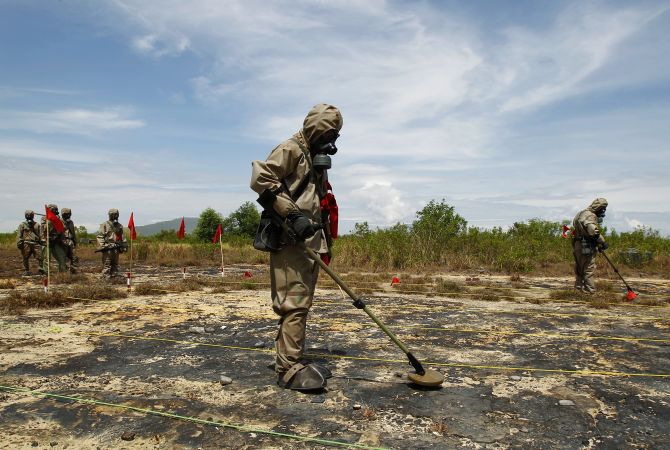 Soldiers detect Unexploded Ordnance (UXO) and defoliant Agent Orange during the launch of the environmental remediation of dioxin contamination project, in Vietnam's central Da Nang City 