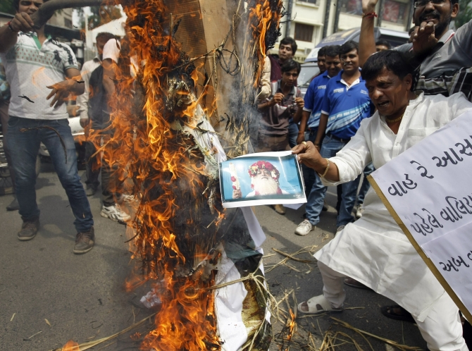 Protesters burn an effigy depicting spiritual leader Asaram Bapu during a protest in Ahmedabad