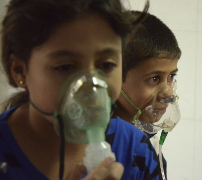Children, affected by what activists say was a gas attack, breathe through oxygen masks in the Damascus suburb of Saqba