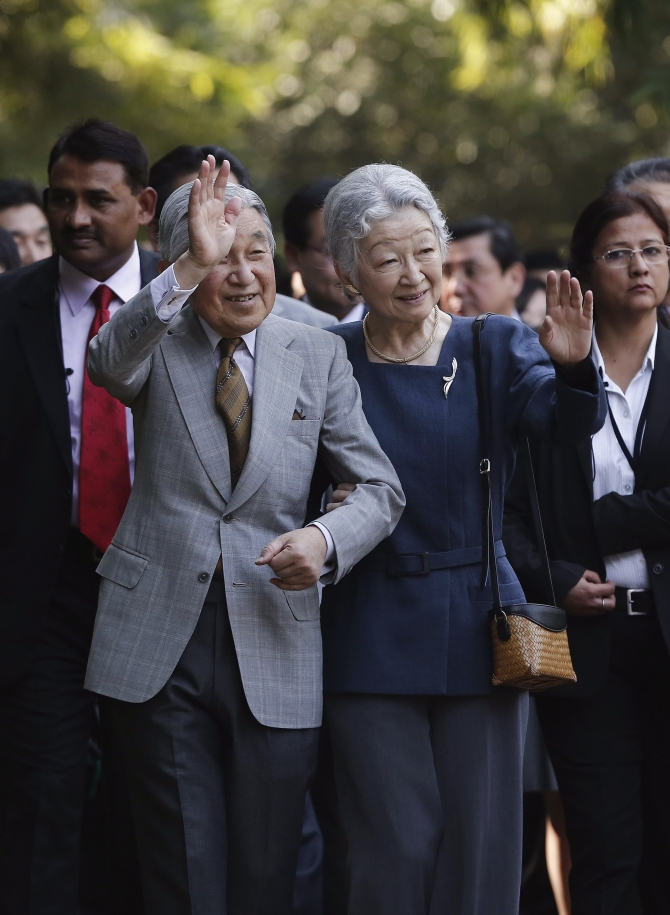 Japan's Emperor Akihito and Empress Michiko wave towards the crowd during their visit to the Lodhi Gardens in New Delhi