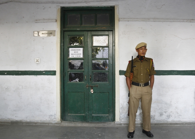 A security personnel stands guard outside the sealed room containing electronic voting machines in New Delhi