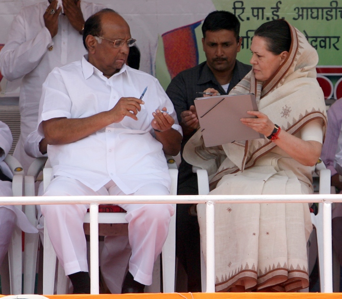 Congress president Sonia Gandhi talks to Nationalist Congress Party chief Sharad Pawar at an election rally