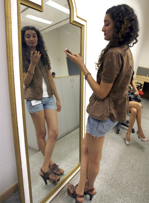 An aspiring model uses her mobile phone during an audition