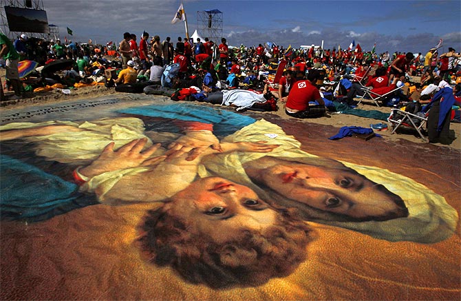 -Catholic faithful camp out next to a giant image of the Virgin Mary and baby Jesus on Copacabana Beach to participate in the all-night vigil before Pope Francis gives mass to those attending the World Youth Day, in Rio de Janeiro