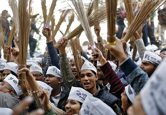 AAP workers celebrate their electoral victory in Delhi with brooms