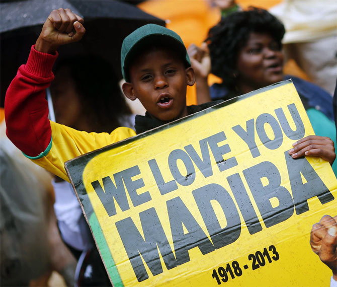 -People start singing as they arrive for a mass memorial for Nelson Mandela