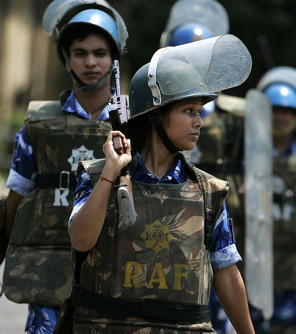 A woman personnel of the Rapid Action Force marches along with male counterparts at a police training school in Kolkata