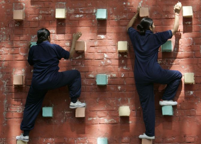 Female members of the Rapid Action Force perform an obstacle climbing exercise at a police training school in Kolkata.
