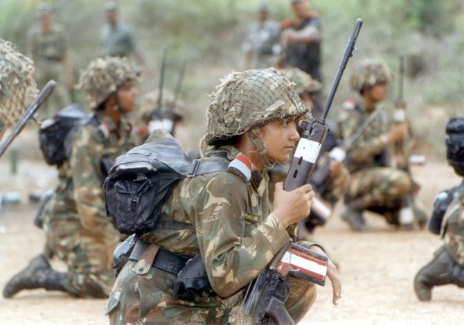 Female soldiers hold transistor radios during a weapons training session at an army camp near Chennai.